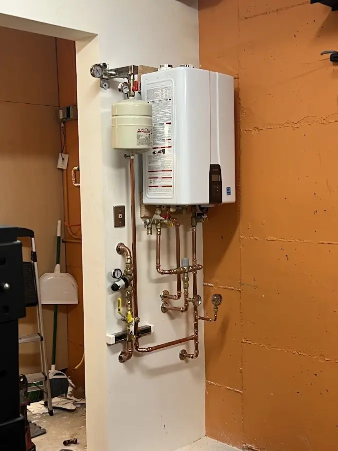 Plumbing technician inspecting water heater connections in Chalmette
